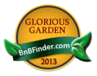 A gold medal emblem for the Black Walnut Point Inn media, featuring the text “GLORIOUS GARDEN,” “BnBFinder.com,” and “2013,” decorated with green leaves.
